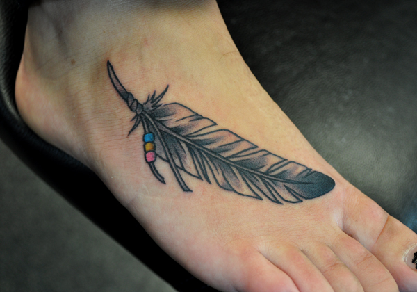Tattoo of a feather on a foot 