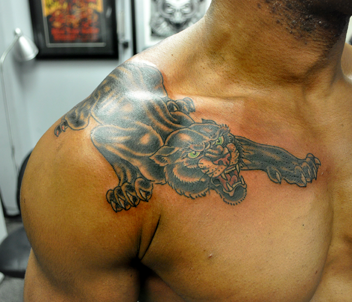 tattoo of a black panther on a man's shoulder and chest 