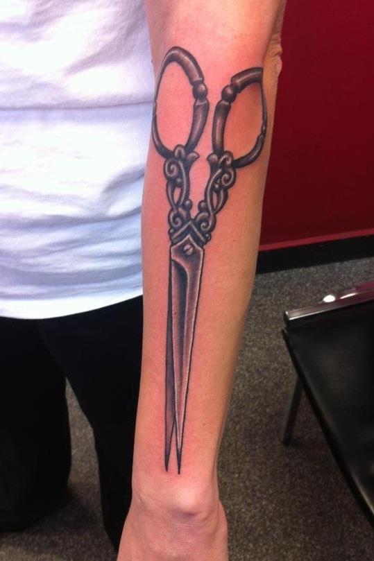 tattoo of scissors on a woman's forearm 